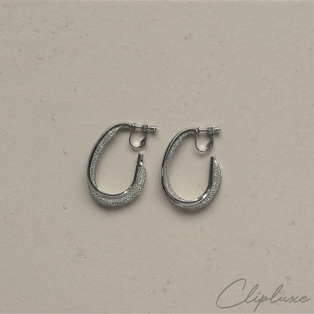 Silver hoop earrings on a beige background with 'Clipluxe' branding.